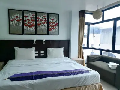 a bedroom with a large bed and a couch at AtWhitePatong in Patong Beach