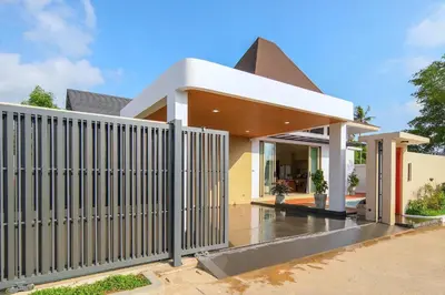 a white fence in front of a house at Phirunda Pool Villas in Ban Suan