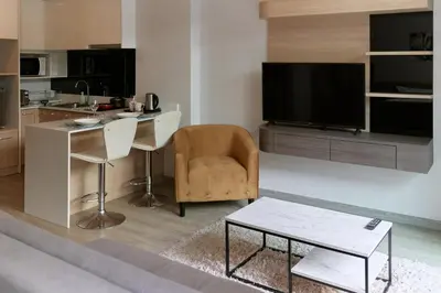 a living room with a television and a table and a chair at Comfy 1-BR Grand Kata VIP condo, 5 min to Kata beach in Kata Beach