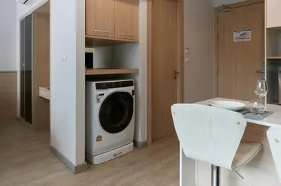a kitchen with a washing machine and a table at Comfy 1-BR Grand Kata VIP condo, 5 min to Kata beach in Kata Beach