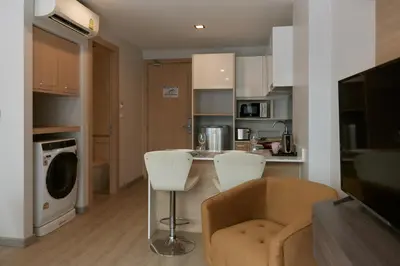a kitchen with a table and chairs in a room at Comfy 1-BR Grand Kata VIP condo, 5 min to Kata beach in Kata Beach