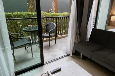a living room with a couch and a table on a balcony at Comfy 1-BR Grand Kata VIP condo, 5 min to Kata beach in Kata Beach