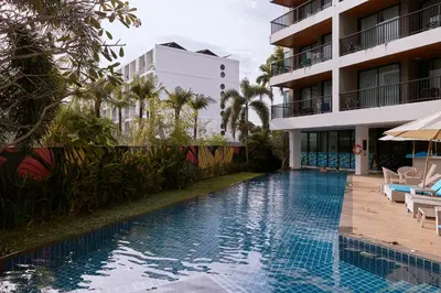 a swimming pool in front of a building at Comfy 1-BR Grand Kata VIP condo, 5 min to Kata beach in Kata Beach