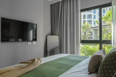 a bedroom with a bed and a large window at The Title Legendary Grand Pool Access in Bang Tao Beach