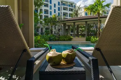 a bowl of coconuts sitting on a table next to two chairs at The Title Legendary Grand Pool Access in Bang Tao Beach