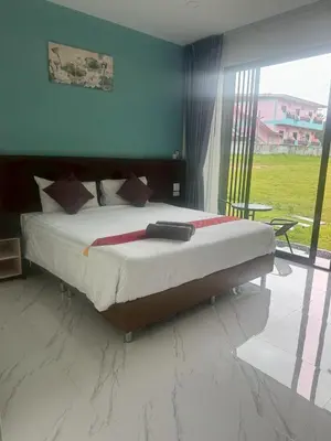 a bedroom with a bed and a large window at Sunisa Resort in Phuket Town