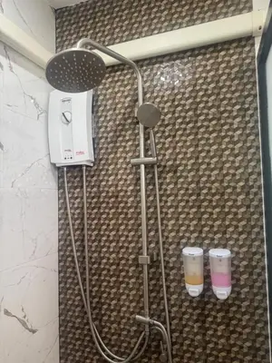 a shower in a bathroom with two cups at Sunisa Resort in Phuket Town