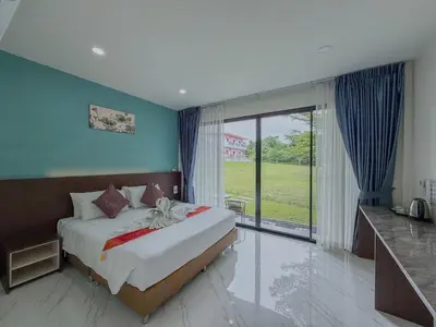 a bedroom with a bed and a large window at Sunisa Resort in Phuket Town