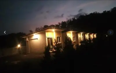 a house lit up at night with lights at Sunisa Resort in Phuket Town