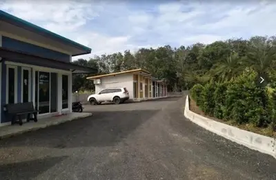 a car is parked in front of a house at Sunisa Resort in Phuket Town