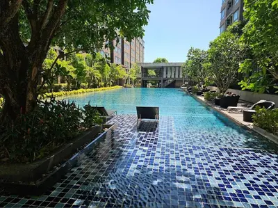 a swimming pool with blue tiles on the ground at Valley Mountain View&City Proximity Golden Eight Apartment in Ban Phlu Yai