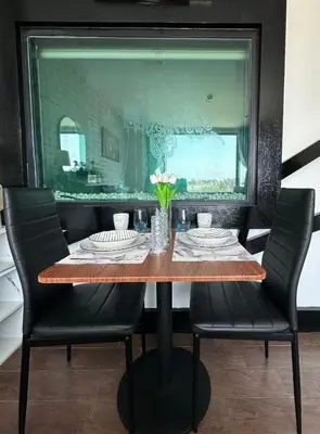 a dining room table with two chairs and a mirror at Grand Patong Apartment 7FL in Patong Beach
