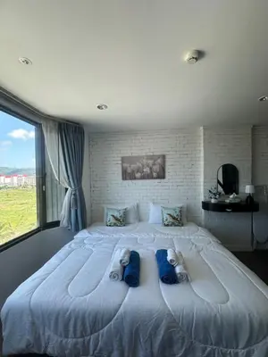 a bedroom with a large white bed with blue pillows at Grand Patong Apartment 7FL in Patong Beach