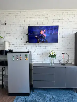a kitchen with a refrigerator and a tv on a wall at Grand Patong Apartment 7FL in Patong Beach