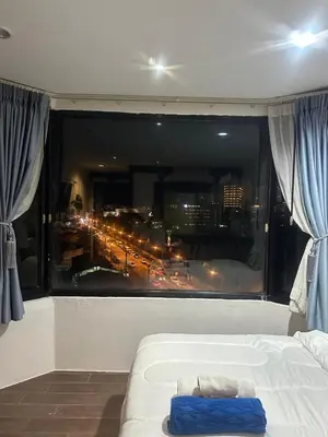 a bedroom with a large window with a view of a city at Grand Patong Apartment 7FL in Patong Beach