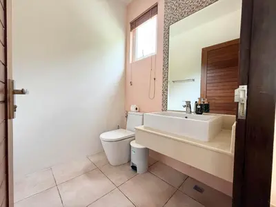 a bathroom with a sink and a toilet and a mirror at Kamala Seaview - 3 BR Private Pool Villa in Kamala Beach