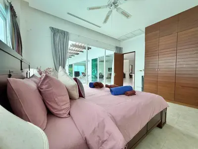 a bedroom with a large bed with pink sheets and pillows at Kamala Seaview - 3 BR Private Pool Villa in Kamala Beach
