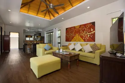 a living room with yellow furniture and a ceiling fan at Private 3BR Pool Villa Mylico 3min drive Nai Harn Beach in Rawai Beach