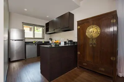 a kitchen with a large wooden door and a refrigerator at Private 3BR Pool Villa Mylico 3min drive Nai Harn Beach in Rawai Beach