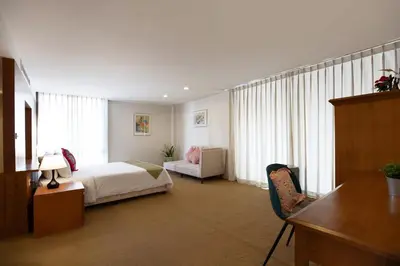 a bedroom with a bed and a desk and a chair at 3 BR Seaview Apt with pool access ADMC 100-2 in Ban Ao Makham