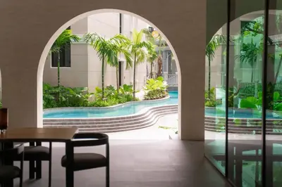 a hotel lobby with a pool and palm trees at Family Title Legendary 2Bdr Bang Tao in Bang Tao Beach