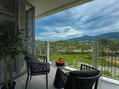 a balcony with a table and chairs and a view at Family Title Legendary 2Bdr Bang Tao in Bang Tao Beach