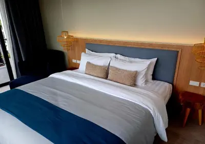 a large bed with a blue headboard and pillows at La La Lay Beach House in Tab Kaek Beach