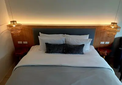 a bed with white pillows and a wooden head board at La La Lay Beach House in Tab Kaek Beach