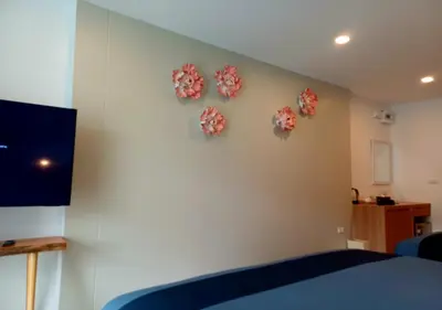 a bedroom with pink flowers on the wall at La La Lay Beach House in Tab Kaek Beach