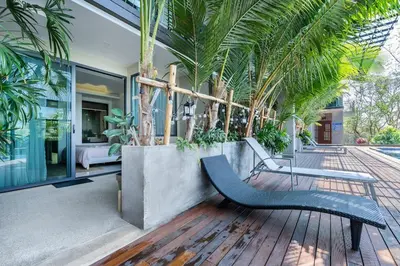 a house with a bench on a wooden deck at Spacious beautiful studio with big patio on the pool side ! in Rawai Beach