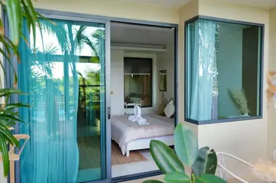 a bedroom with a bed and a sliding glass door at Spacious beautiful studio with big patio on the pool side ! in Rawai Beach