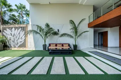 a living room with a couch and palm trees at Spacious beautiful studio with big patio on the pool side ! in Rawai Beach