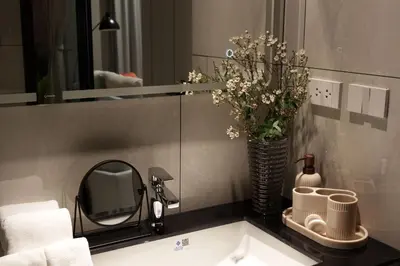 a bathroom sink with a mirror and a vase of flowers at Cozy 1 Bdr Title Legendary Bang Tao 5 min to the Beach in Bang Tao Beach