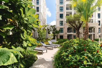 a row of benches in a garden with buildings at Cozy 1 Bdr Title Legendary Bang Tao 5 min to the Beach in Bang Tao Beach