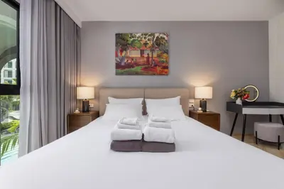 a bedroom with a large white bed with two pillows at Oliva 1BR Suite — The Title Legendary BangTao in Bang Tao Beach