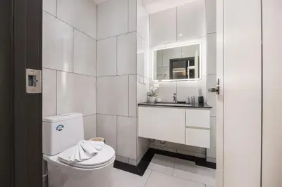 a white bathroom with a toilet and a sink at Oliva 1BR Suite — The Title Legendary BangTao in Bang Tao Beach