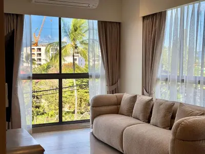 a living room with a couch and a large window at Laguna Lakeside by Villacarte in Bang Tao Beach