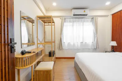 a bedroom with a large bed and a window at The Banyan House in Patong Beach