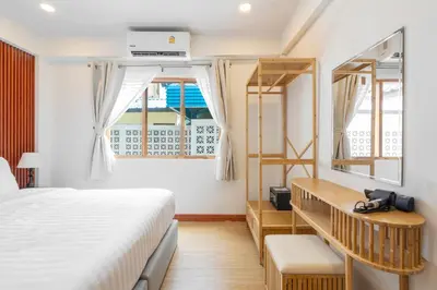 a bedroom with a bed and a window at The Banyan House in Patong Beach