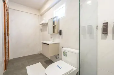 a bathroom with a toilet and a glass shower at The Banyan House in Patong Beach