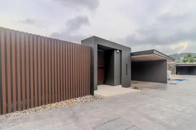 a building with a wooden fence next to it at V263 Brand New 3BR Super Modern Pool Villa - Calathea in Thalang