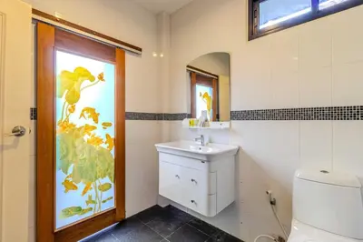 a bathroom with a toilet and a sink and a window at V265 2BR Pool Villa Near Fitness Gyms Muay Thai in Ban Saiyuan (1)