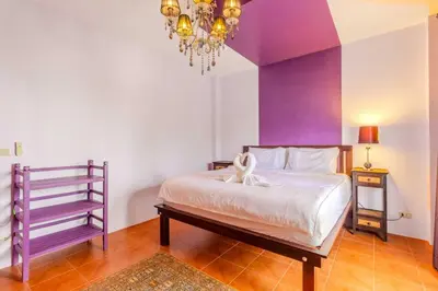 a bedroom with a bed with purple walls and a chandelier at V265 2BR Pool Villa Near Fitness Gyms Muay Thai in Ban Saiyuan (1)