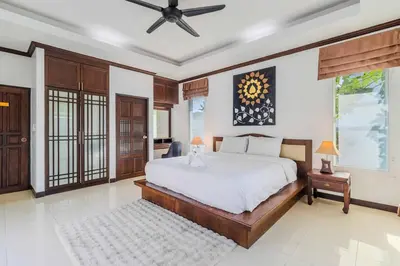 a bedroom with a bed and a ceiling fan at V267 Newly Renovated 2BR with Pool Near Beaches in Ban Saiyuan (1)