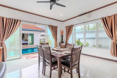 a dining room with a table and chairs at V267 Newly Renovated 2BR with Pool Near Beaches in Ban Saiyuan (1)