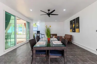 a dining room with a table and a ceiling fan at V267 Newly Renovated 2BR with Pool Near Beaches in Ban Saiyuan (1)