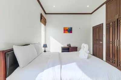 a white bedroom with a large white bed at V267 Newly Renovated 2BR with Pool Near Beaches in Ban Saiyuan (1)