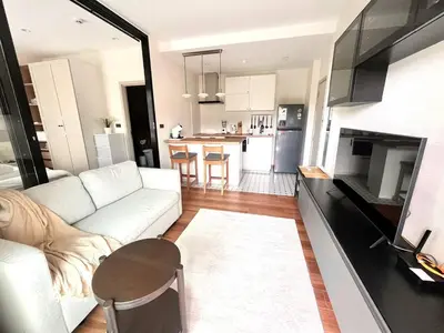 a living room with a white couch and a kitchen at MO607 1 br 36m in Nai Yang Beach