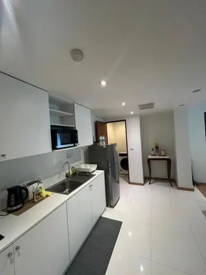 a kitchen with white cabinets and a stainless steel refrigerator at The Privilege by Tris in Patong Beach