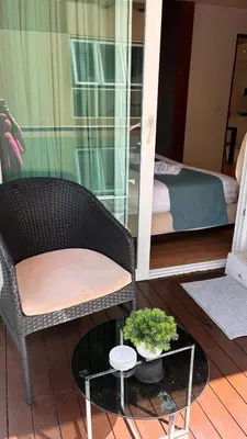 a room with a chair and a bed and a table at The Privilege by Tris in Patong Beach